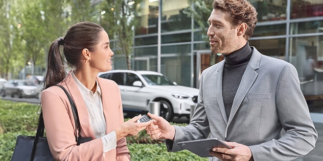 Two BMW drivers chat with a BMW in the background