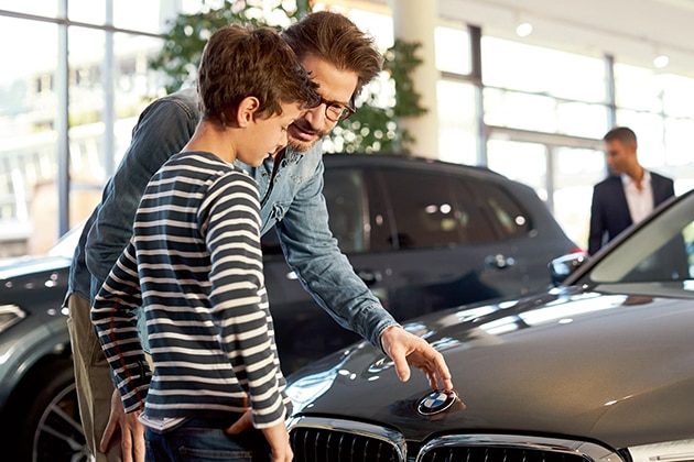 A father and son check out a vehicle inside a BMW Center