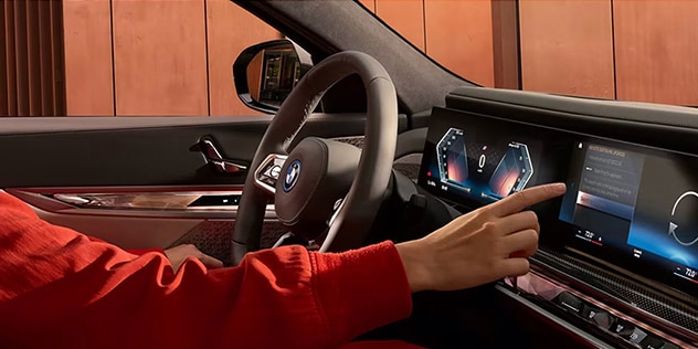 Interior shot of a woman interacting with the BMW Curved Display