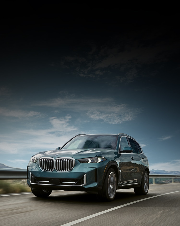 A BMW SUV driving down a scenic highway