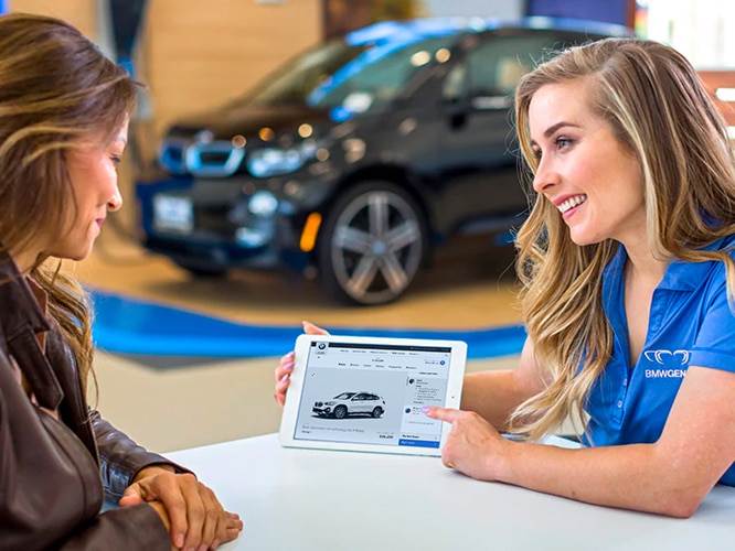 Product specialist at BMW Center helping a BMW driver on a tablet
