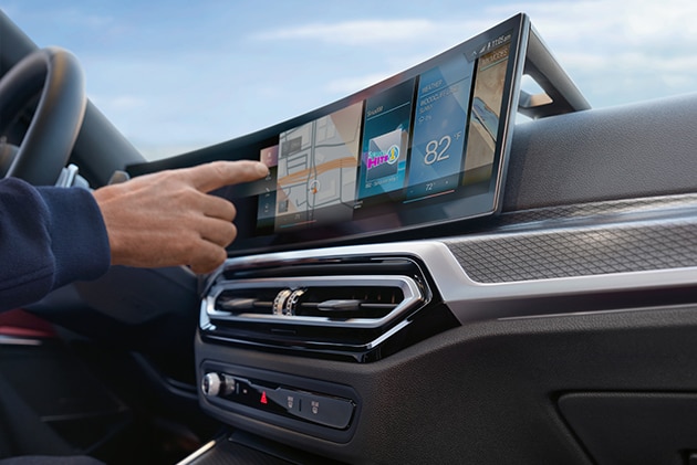 A BMW driver utilizing the BMW Curved Display to control various features on the vehicle.