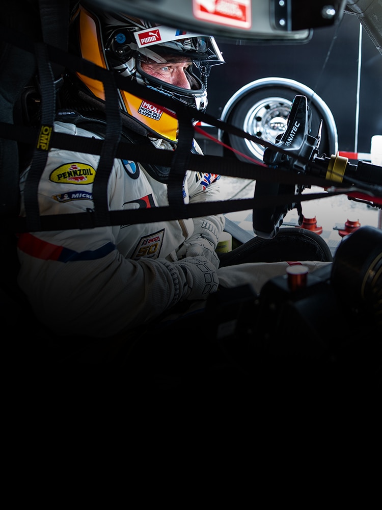 A professional driver in the cockpit of a BMW race car