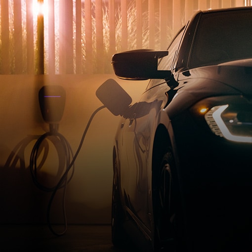 Cropped view of the 2025 BMX iX parked in a home garage, plugged into a charging station.
