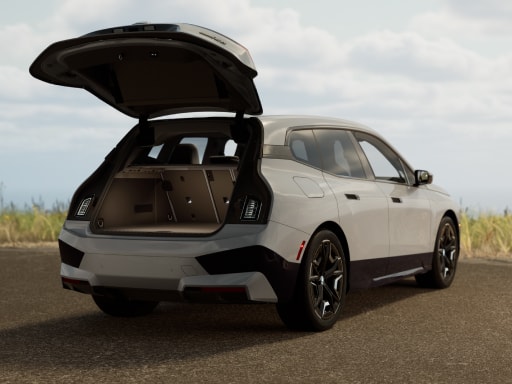 Extrior rear three-quarters image of a BMW iX with its tailgate open, showing off the ample cargo capacity of 35.5 cubic feet. 