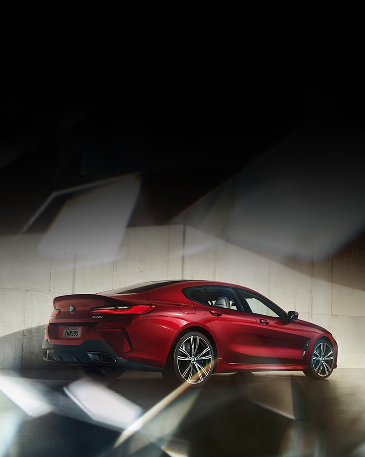 A rear quarter view of a BMW 840i Gran Coupe in Aventurin Red Metallic