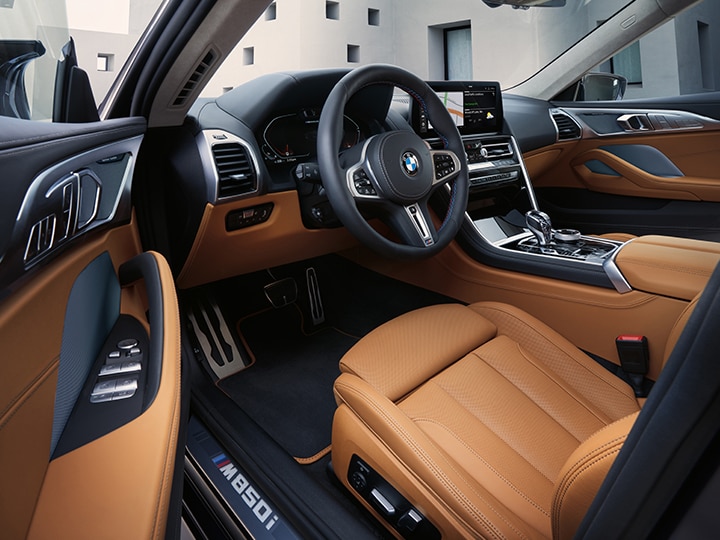 Cabin of the 2026 BMW M850i xDrive Gran Coupe as seen from the open driver's door