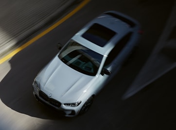 Aerial shot of the 2025 BMW X4 driving down a curvy road