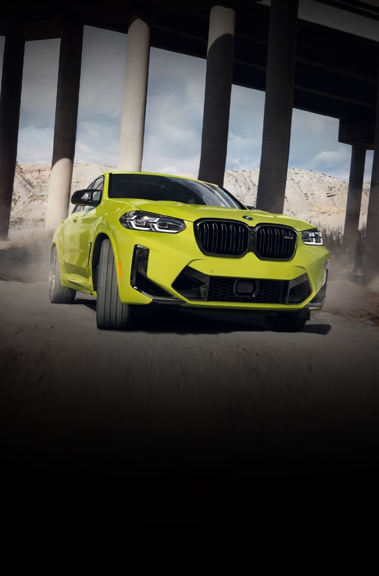 2025 BMW X4 M Performance Coupe SUV driving on a dirt road