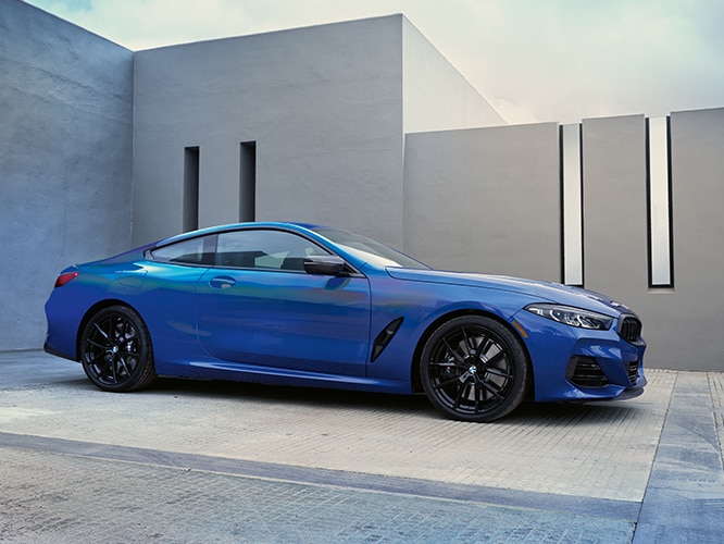 Side profile of the 2026 BMW M850i xDrive Coupe parked in a driveway