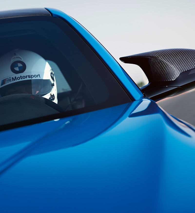 Close up shot of racecar driver driving the Limited Edition BMW M2 CS in Misano Blue around the racetrack 