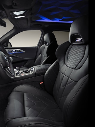 The interior of the BMW XM by Kith, including the driver and passenger seat with Kith logo and embossed upholstery.