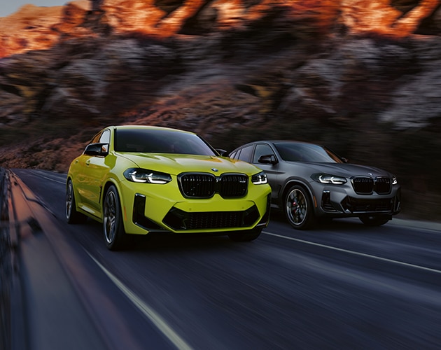 The BMW X4 M and X4 M40i drive side by side down a roadway